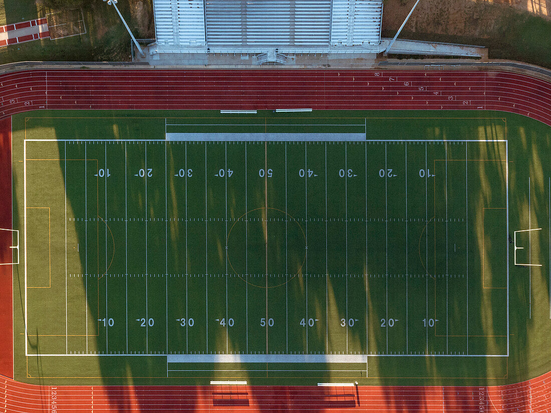 Luftaufnahme einer Highschool-Bahn und eines Fußballfeldes in Texas bei Sonnenaufgang