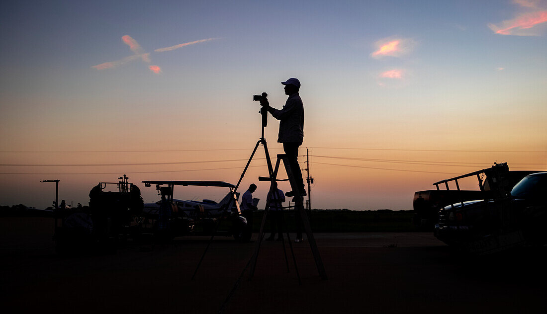 Silhouetted Photographer at an Airfield During Sunset