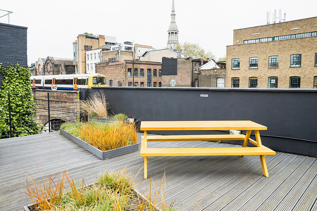 Detail of rooftop patio in London with train passing by