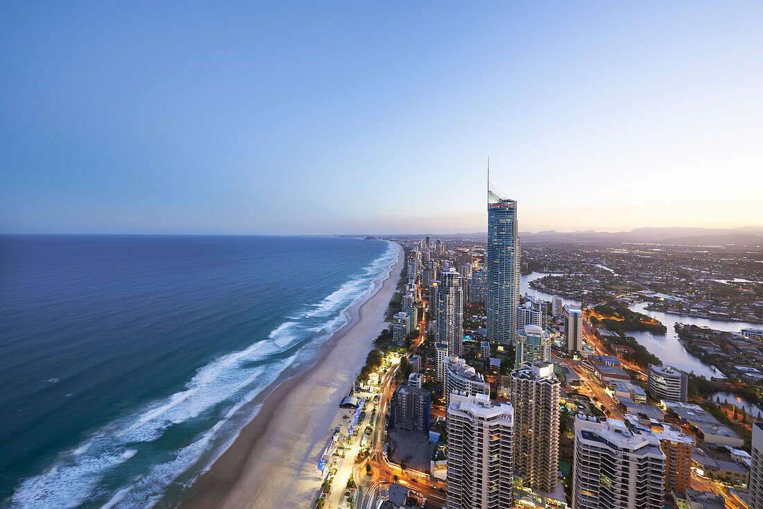 Panorama aerial of Surfers Paradise and surrounding suburbs early evening with light on in buildings