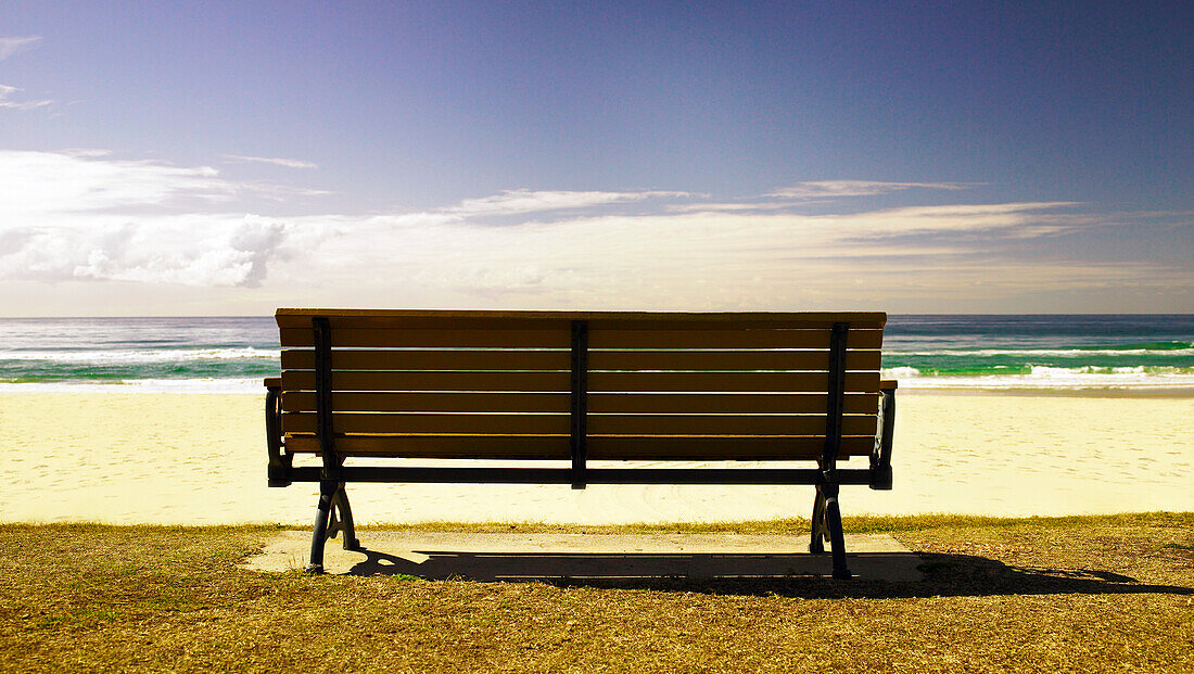 Empty seat in front of beautiful beach with gentle waves rolling onto shore