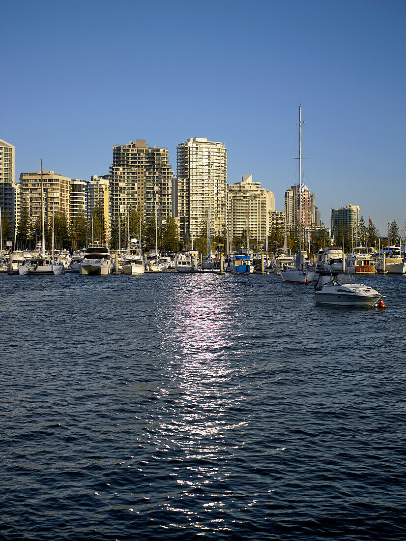 Looking from Marina Mirage across broadwater at boats moored and highrise apartment buildings in Southport