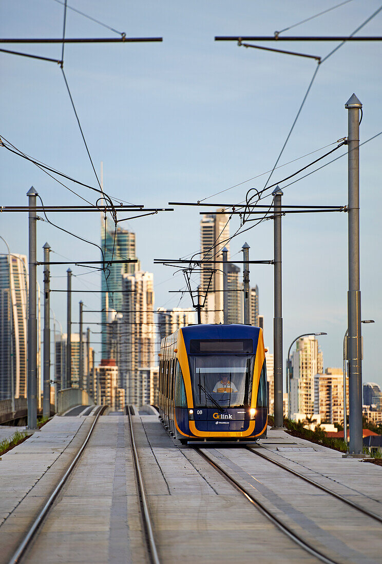 Tram travelling on lines and Surfers Paradise City in the background