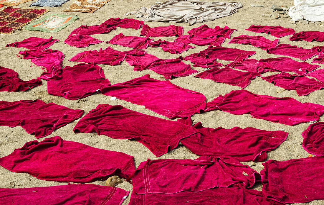 Am Strand von Mumbai liegen rosafarbene Handtücher