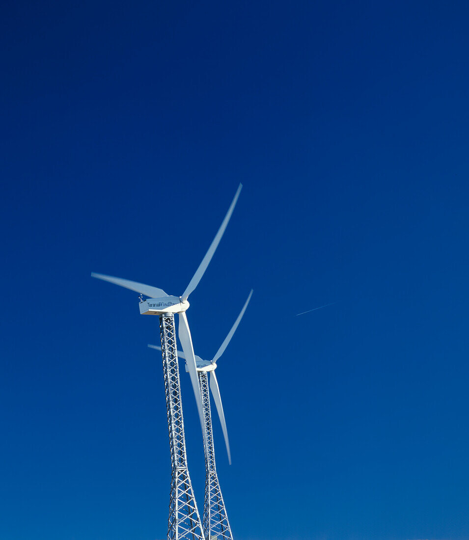 Zwei Windkraftanlagen gegen blauen Himmel