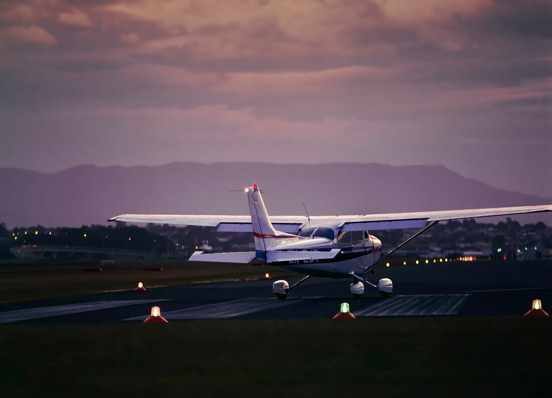 Privatflugzeug bereitet sich in der Dämmerung auf den Start auf der Landebahn vor