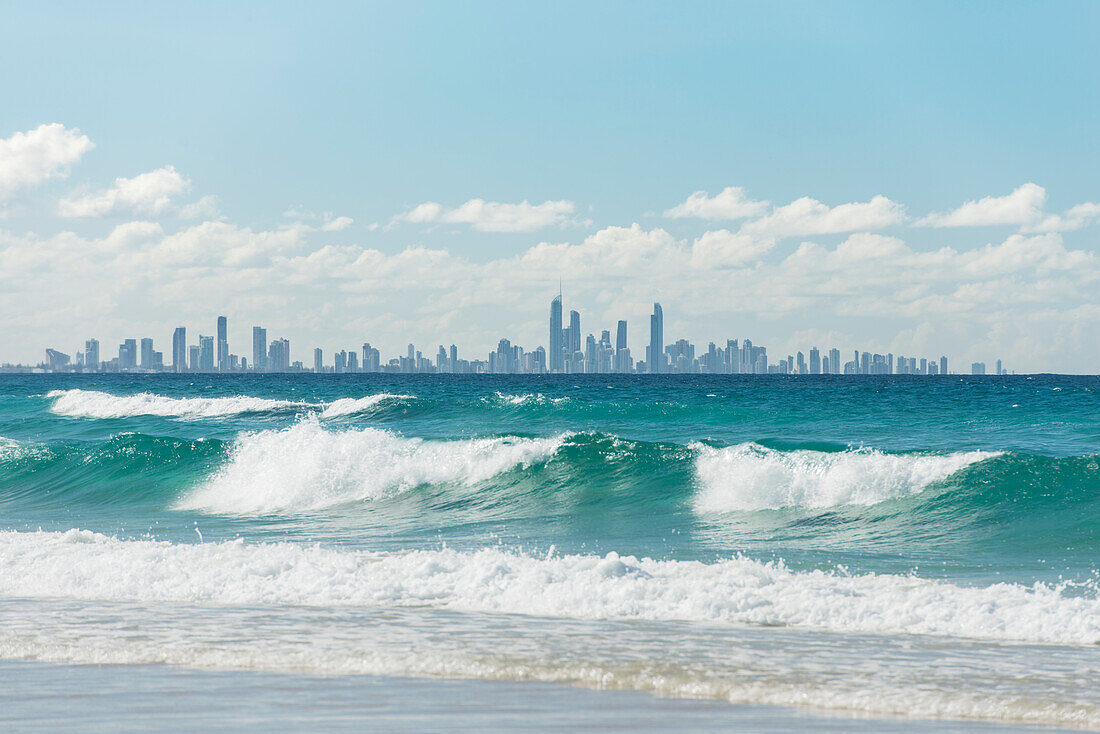 Looking across waves at Kirra Beach to city skyline of Surfers Paradise