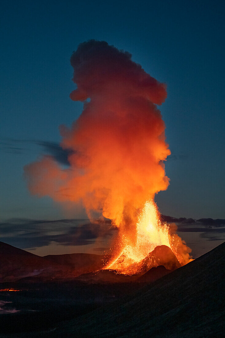 Halbinsel Reykjanes, Island - 9. Mai 2021: Geldingadalir-Ausbruch in der Abenddämmerung mit orangefarbener Rauchwolke über dem Krater