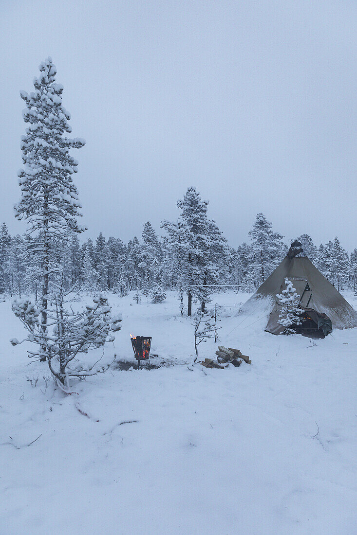 Camping-Tipi-Zelt und Feuerstelle. Winterszene in Schwedisch Lappland