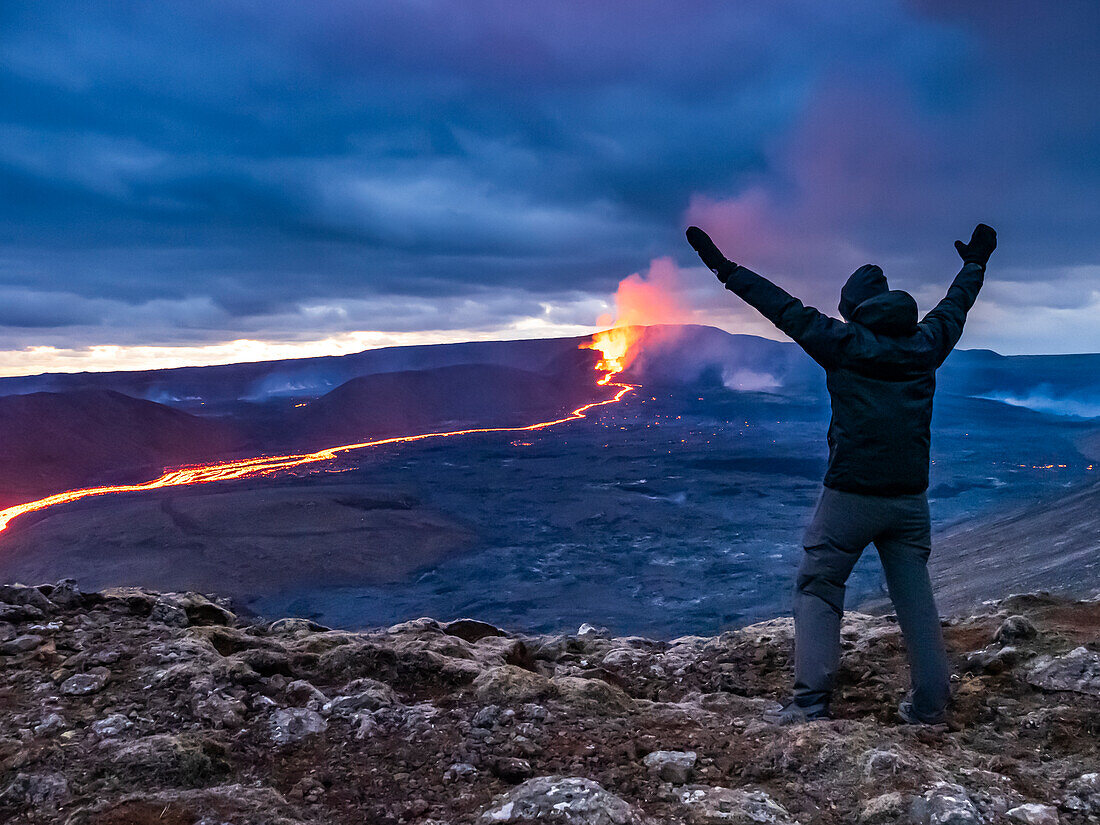 Feier, Wanderer sieht glühenden Fluss aus Magma und den Vulkanausbruch des Fagradalsfjall in Geldingadalir, Island