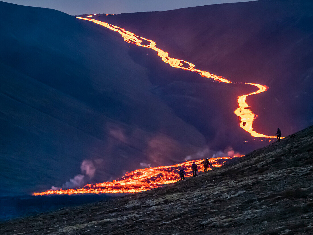 Wanderer betrachten den glühenden Magmastrom des Vulkanausbruchs Fagradalsfjall bei Geldingadalir, Island