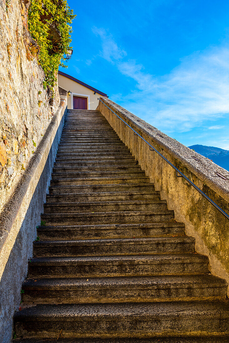 Treppe zur Kirche Santa Maria del Sasso gegen den blauen Himmel auf dem Berg an einem sonnigen Tag in Morcote, Tessin in der Schweiz