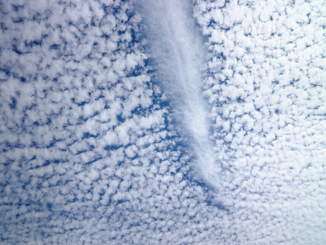 Jetstream dissipating path through fluffy clouds