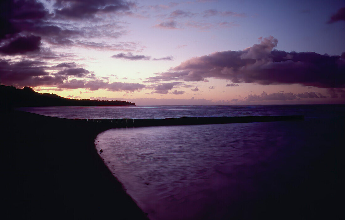 Lila Sonnenuntergang über der Küste von Rarotonga im Pazifischen Ozean