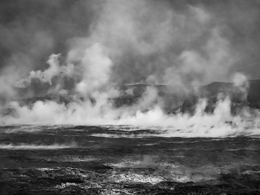Schwarz-Weiß-Aufnahme, Dampf steigt aus einem Lavasee auf, der das Tal um den Vulkan Fagradalsfjall füllt, Island
