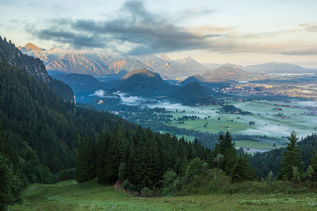 View of the valley on Füssen and Hohenschwangau Castle in the Allgäu at sunrise. Fussen, Swabia, Bavaria, Germany, Europe