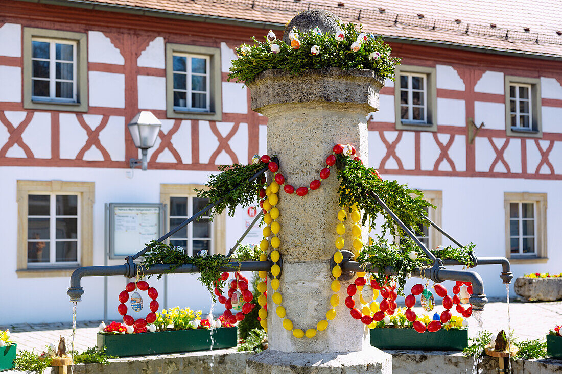 mit bunten Ostereiern geschmückter Osterbrunnen vor dem Rathaus am Marktplatz in Markt Heiligenstadt in der Fränkischen Schweiz, Bayern, Deutschland