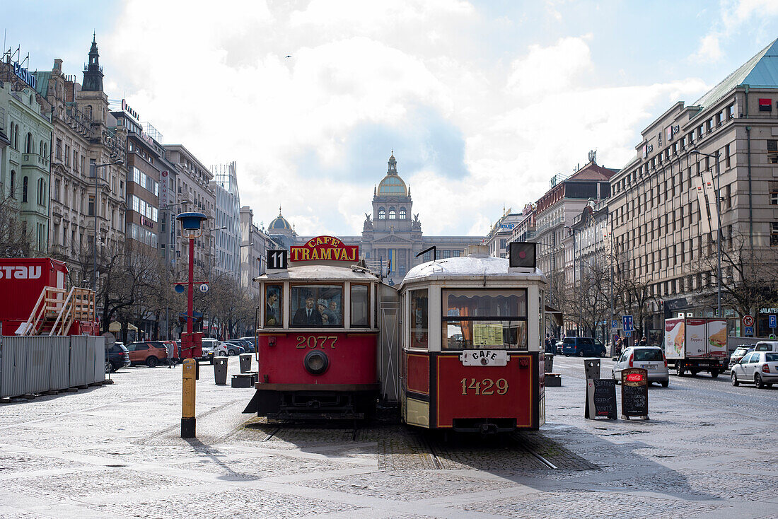 Two historic trams, serving as a café, behind them Wenceslas Square, Prague, Czech Republic