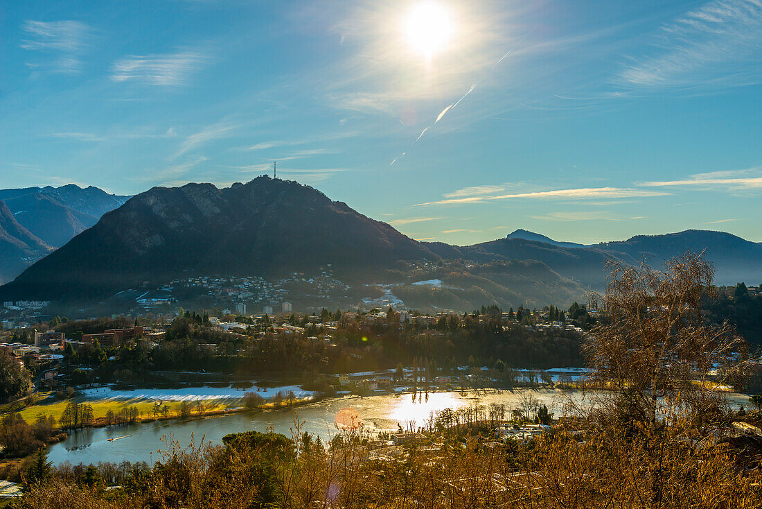 Mountain View in a Sunny Winter Day over Lake Muzzano with Ice in a Sunny Day in Lugano, Ticino in Switzerland.