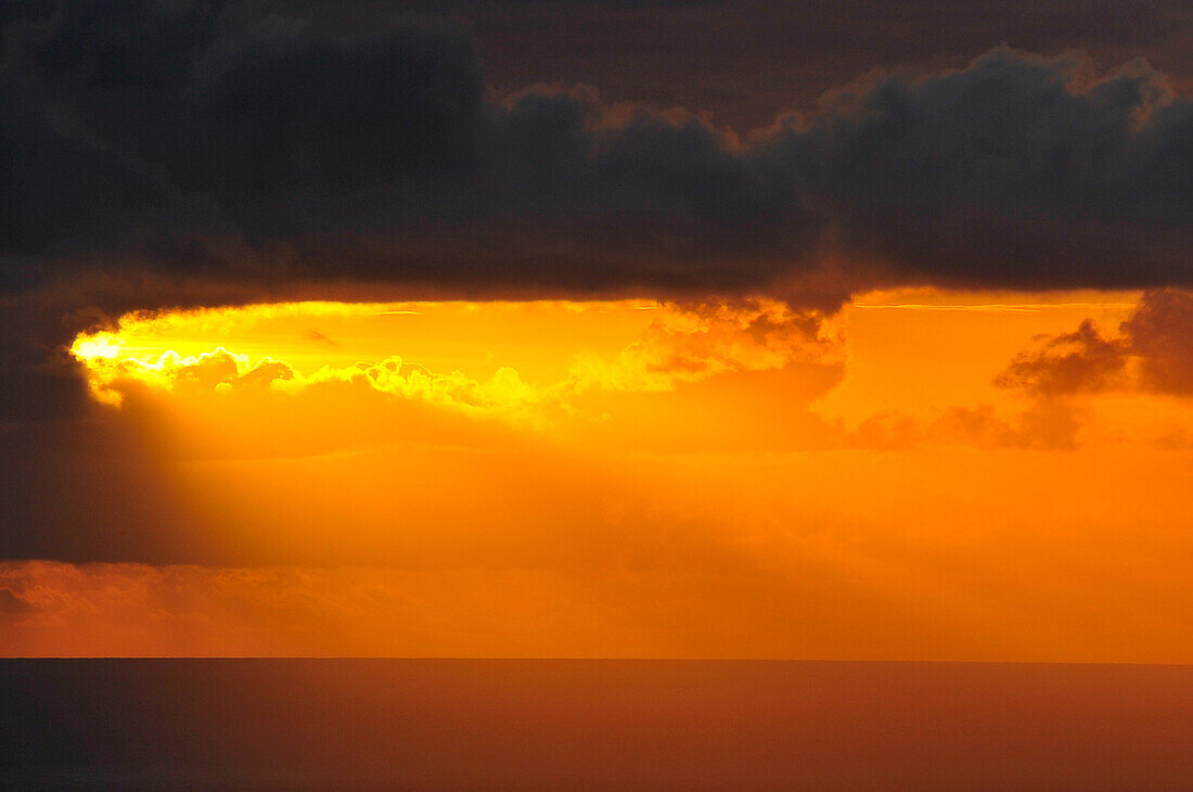 Dunkle Wolken im intensiven Sonnenuntergang über dem Atlantik, La Palma, Spanien