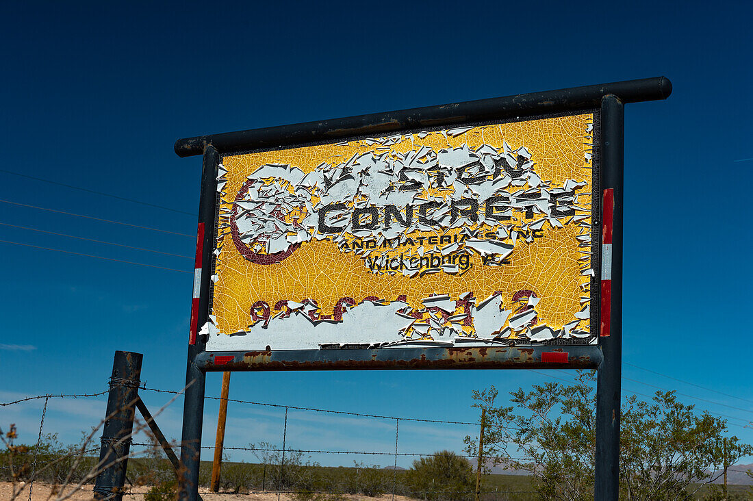 Weathered colorful company sign against a deep blue sky, Wickenburg, Arizona, USA