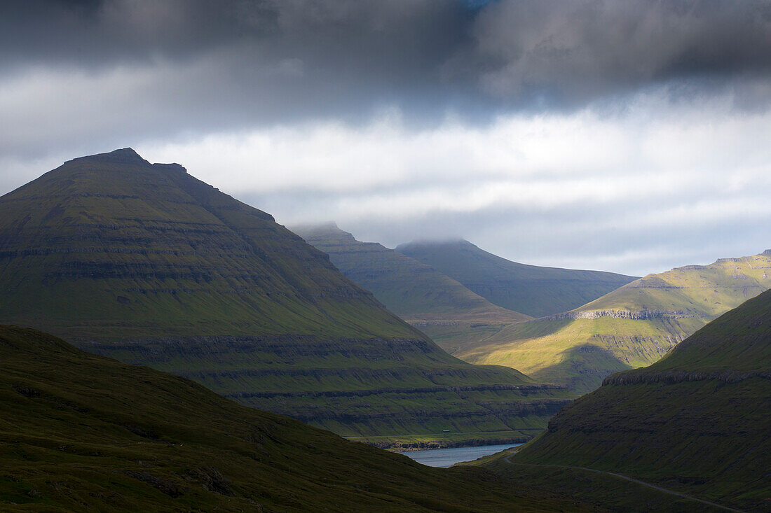 Funning Fjord, Eysturoy, Faroe Islands. light, shadow. rain clouds. green mountains.