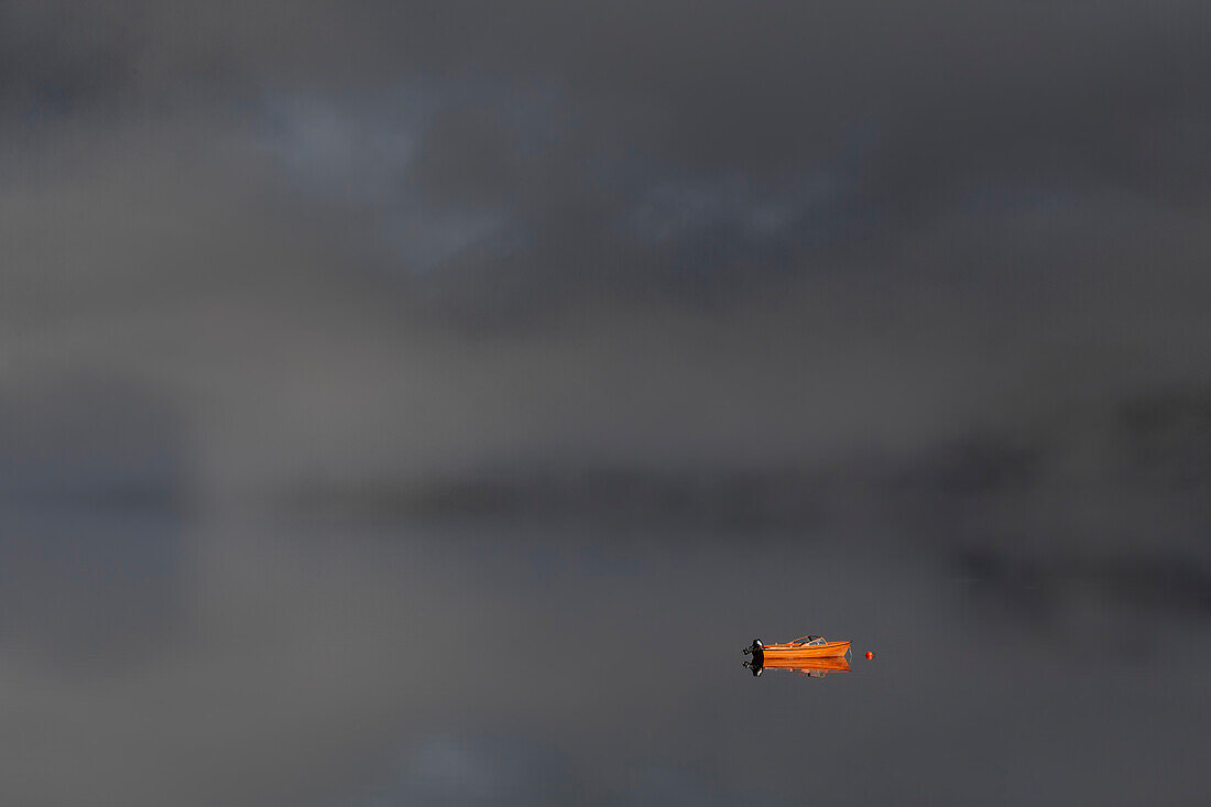 Einsames Motorboot auf spiegel glattem Wasser, Nebel, Reflektionen, Troms, Botnham, Senja, Norwegen.