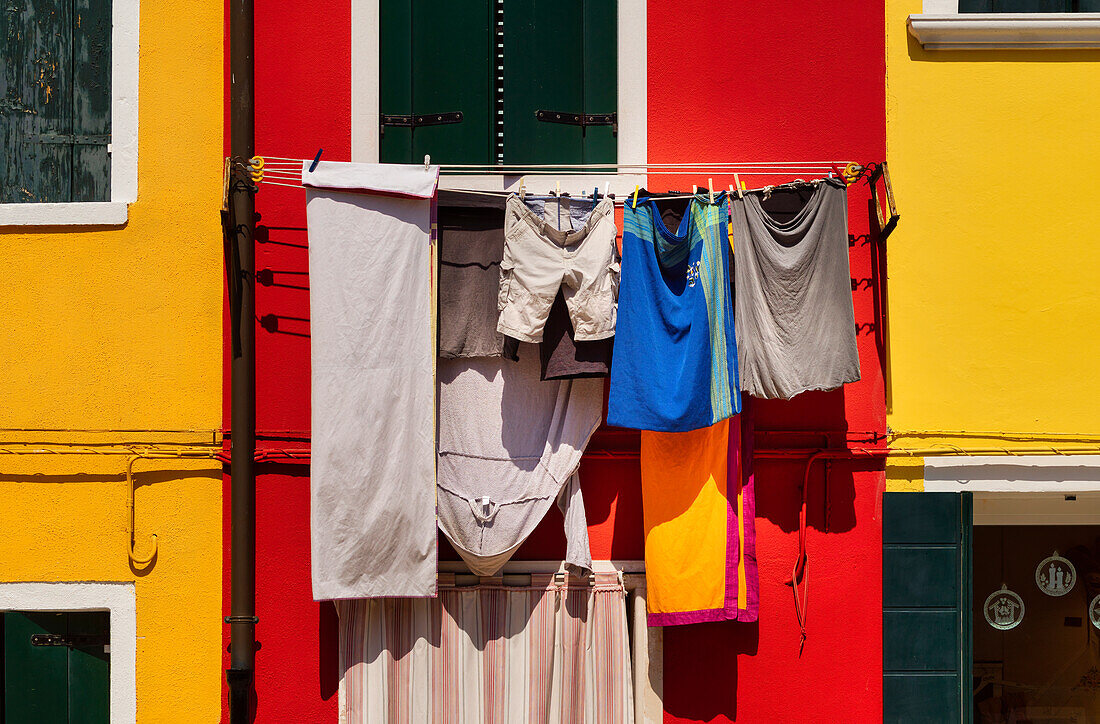 Trocknende Wäsche vor farbefroher Fassade in Burano, Venedig, Venetien, Italien, Europa