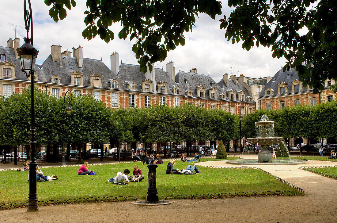 Menschen sitzen im Park am Place des Vosges, Marais, Paris, Frankreich