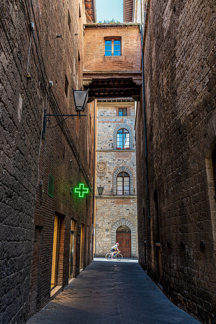 Rennradfahrer, Apotheke mit Verbinding zweier Häuser, in der Altstadt, Siena, Toskana, Italien, Europa