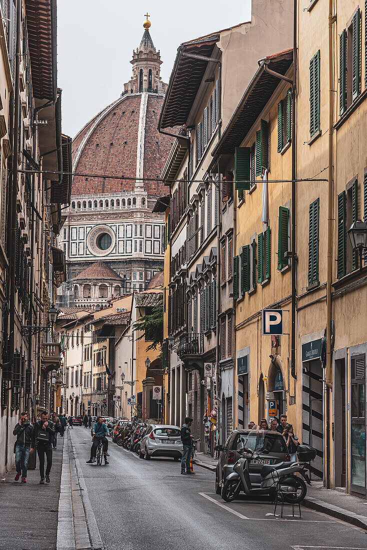 Fahrradfahrer in Gasse mit Dom, Kathedrale Santa Maria del Fiore im Hintergrund, Florenz, Toskana, Italien