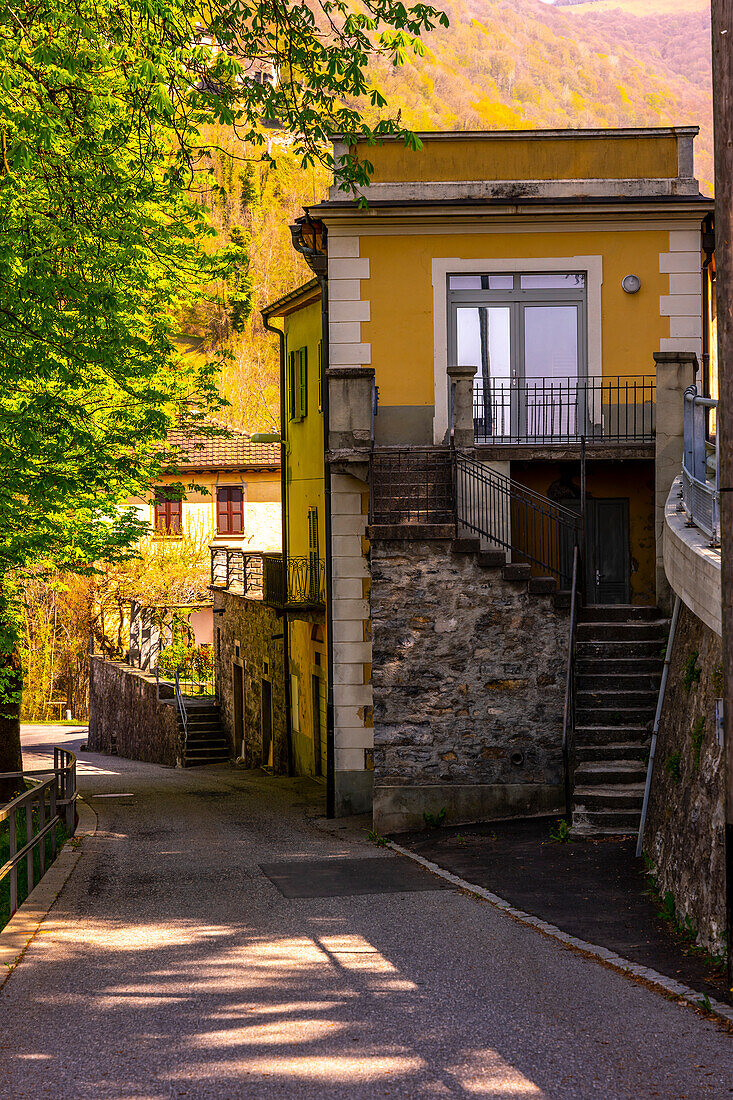 Altstadt im Muggiatal mit Bergstraße an einem sonnigen Tag im Tessin, Schweiz