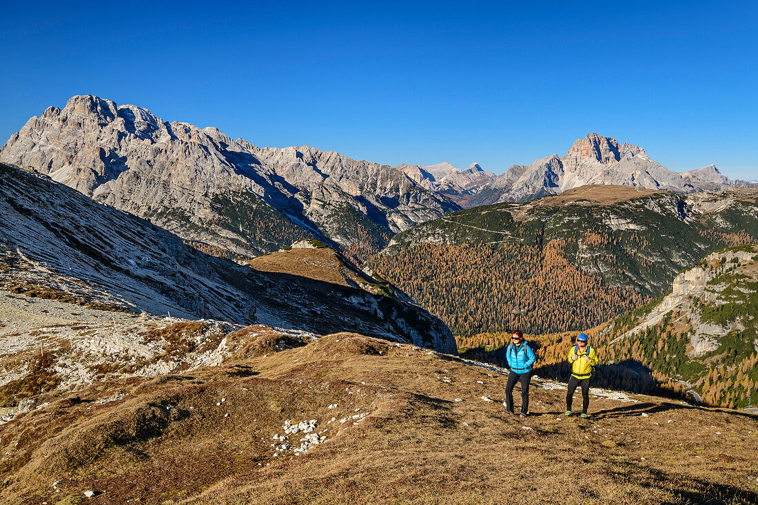 Mann und Frau beim Wandern mit Monte Cristallo und Hohe Gaisl im Hintergrund, am Monte Campedelle, Drei Zinnen, Dolomiten, UNESCO Weltnaturerbe Dolomiten, Venetien, Venezien, Italien
