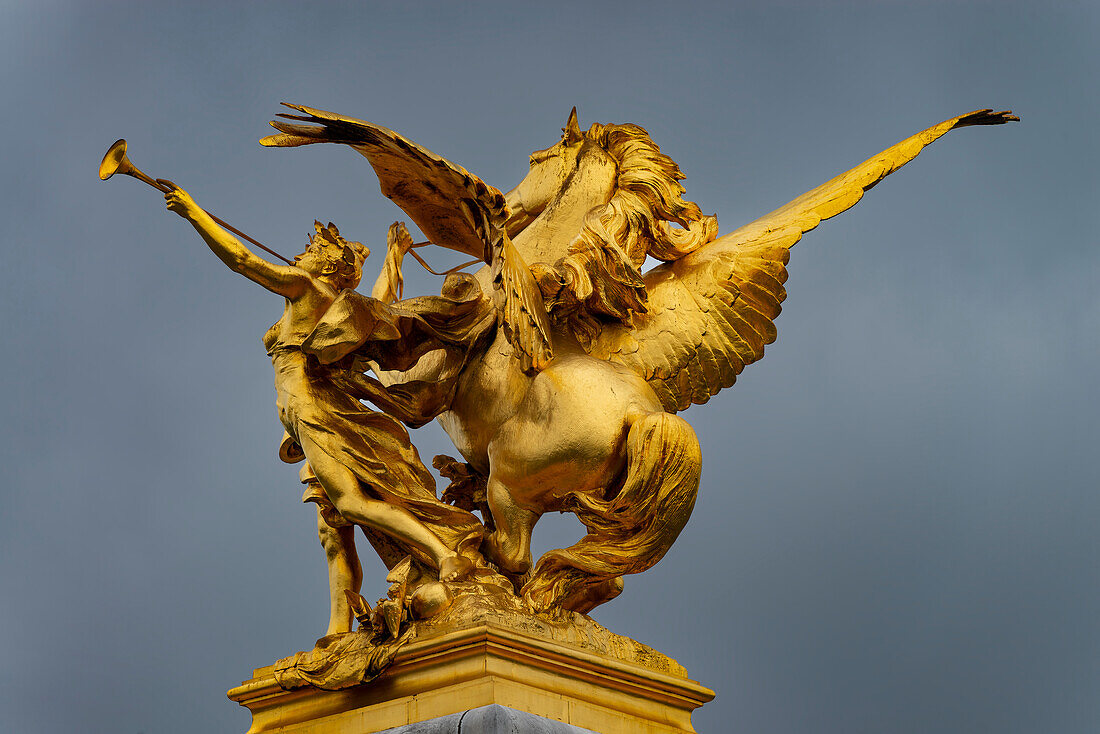 Column with the figure group 'Fama of War' on the bridge Pont Alexandre III. across the river Seine, Paris, France, Europe