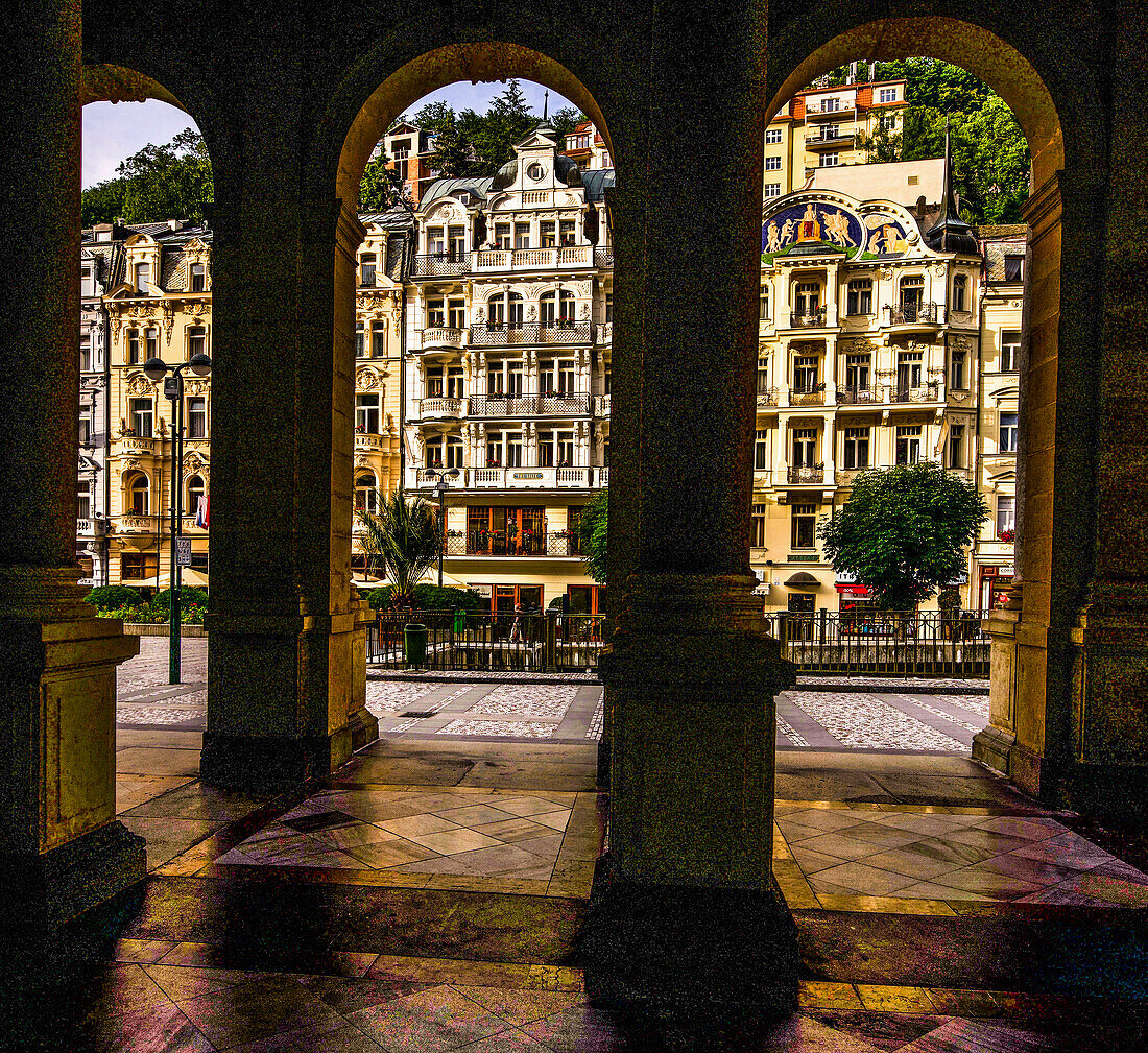 View through the arcades of the Mill Fountain Colonnade to the historic buildings on Cross Street (Vridelni), Karlovy Vary, Karlovy Vary, Czech Republic