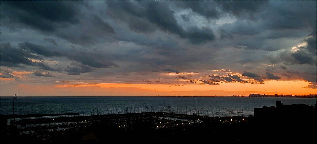 Stürmischer Himmel bei Sonnenuntergang in El Masnou, Maresme, Barcelona, Spanien