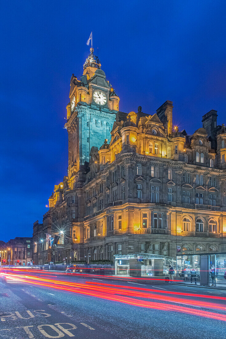 Uhrturm des Balmoral Hotels nachts beleuchtet mit Ampelunschärfe unten, Edinburgh, UK