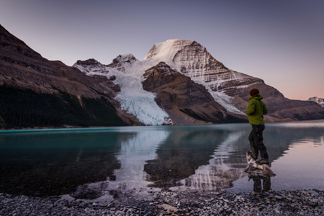 Man looking at Mount Robson above Berg lake at dawn, Canada