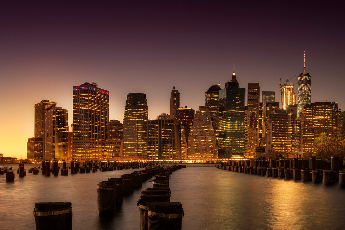 Manhattan skyscrapers lit up at dawn.