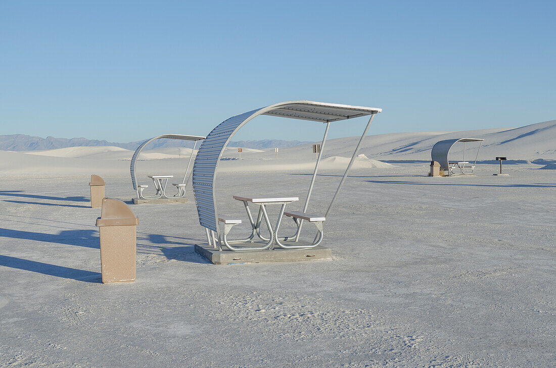 Shelters and trash bins among gleaming white sand dunes, White Sands National Monument, USA