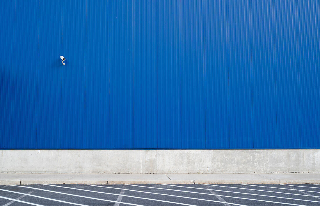 Überwachungskamera an einer blauen Außenwand eines Lagerhauses oder eines großen fensterlosen Gebäudes, Philadelphia, USA