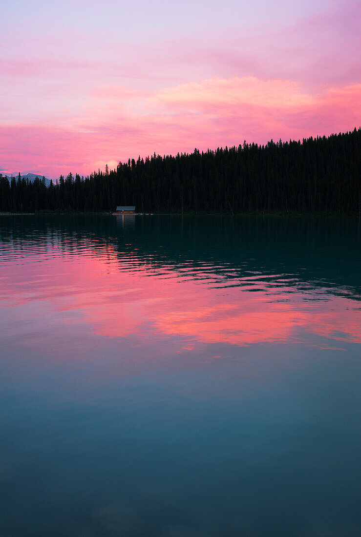 Lake Louise mit Reflexionen des rosa Himmels bei Sonnenuntergang, Kanada