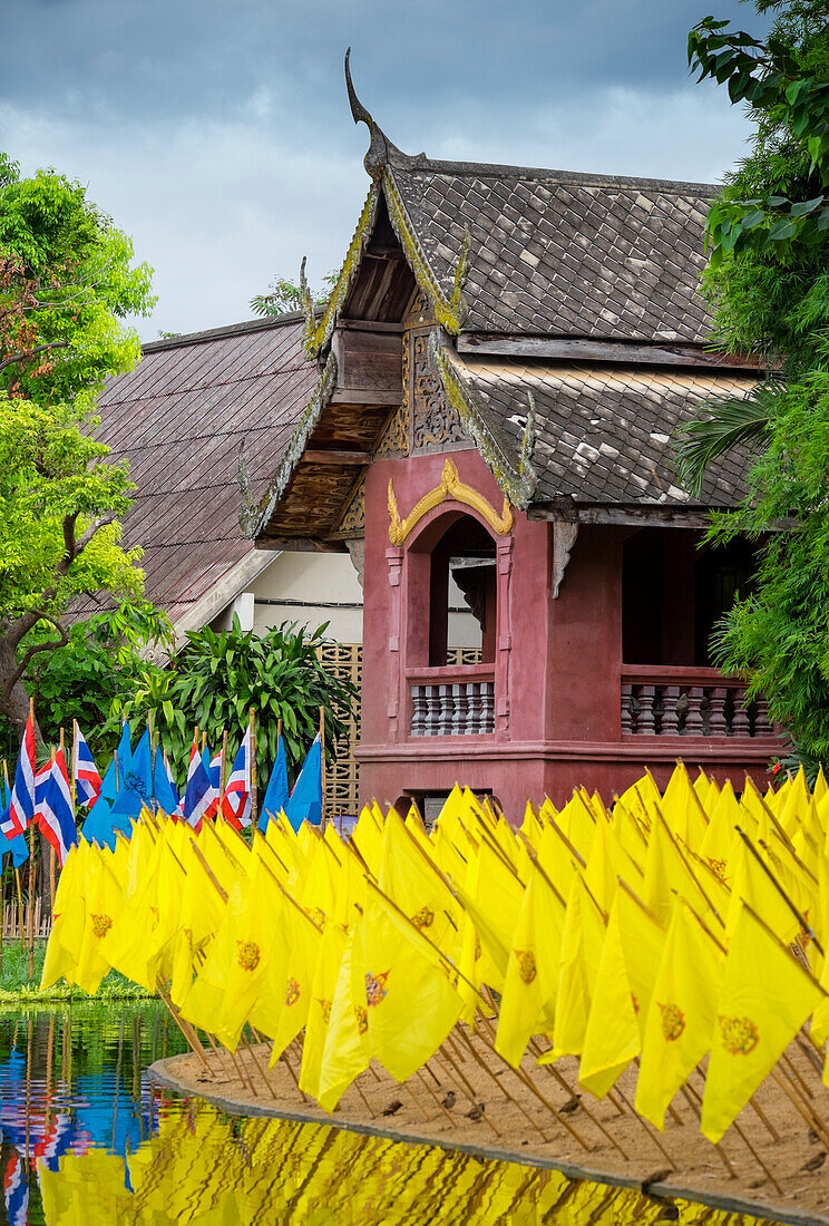 Gelbe Gebetsfahnen vor einem Wat-Tempel, leuchtende Farben, Thailand