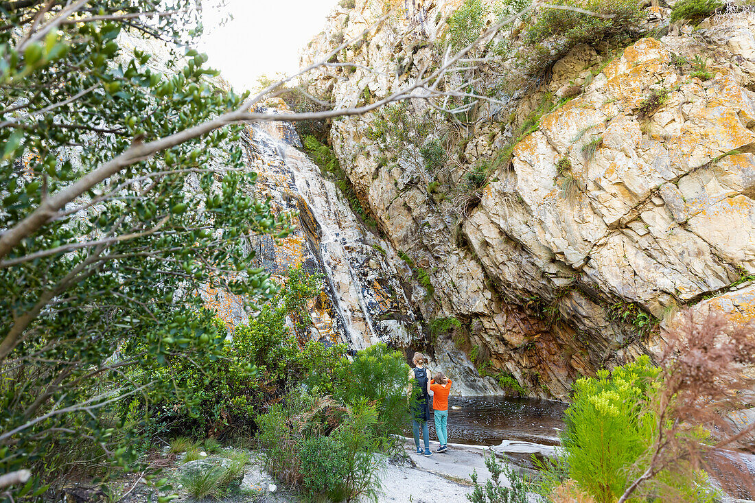 Teenager-Mädchen und jüngerer Bruder wandern den Waterfall Trail, Stanford, Südafrika.