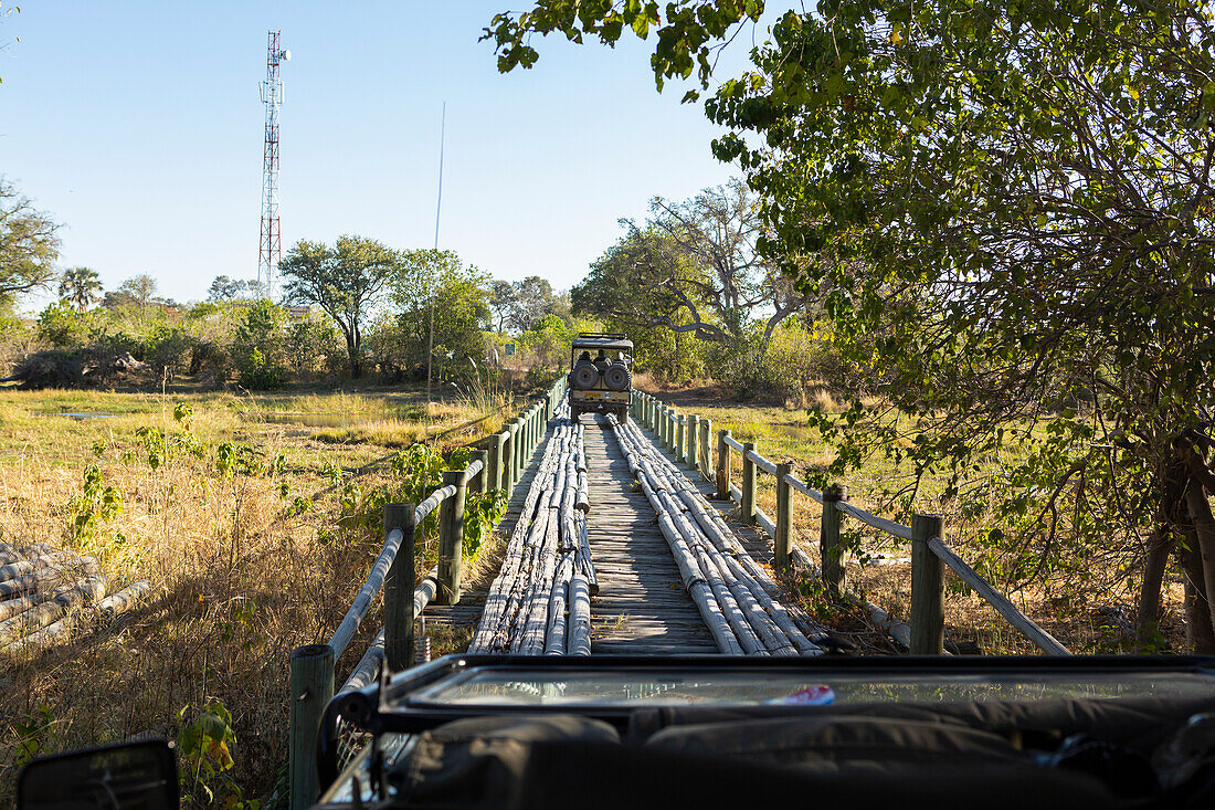 Safari vehicle crossing Fourth Bridge, Okavango Delta,  Botswana.