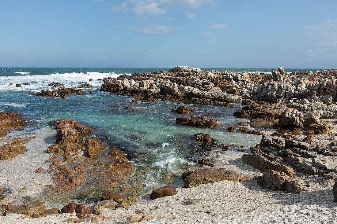 Rock pools and jagged coastline rocks on a beach, the Atlantic coast, De Kelders Beach, South Africa