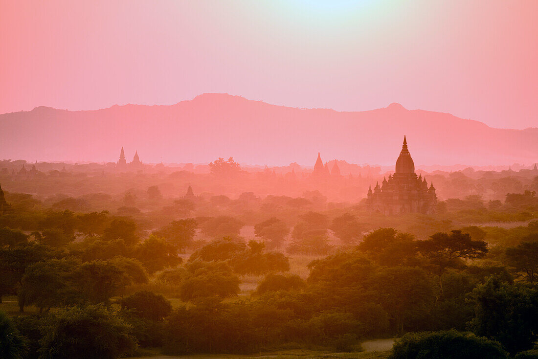 Morgendämmerung und Nebel in der Luft über dem Tempel auf der Ebene in Mandalay, Myanmar