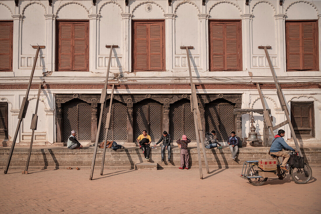 Locals sit at the Royal Palace which has to be supported due to earthquake damage, Bhaktapur, Durbar Square, Lalitpur, Kathmandu Valley, Nepal, Himalaya, Asia, UNESCO World Heritage Site