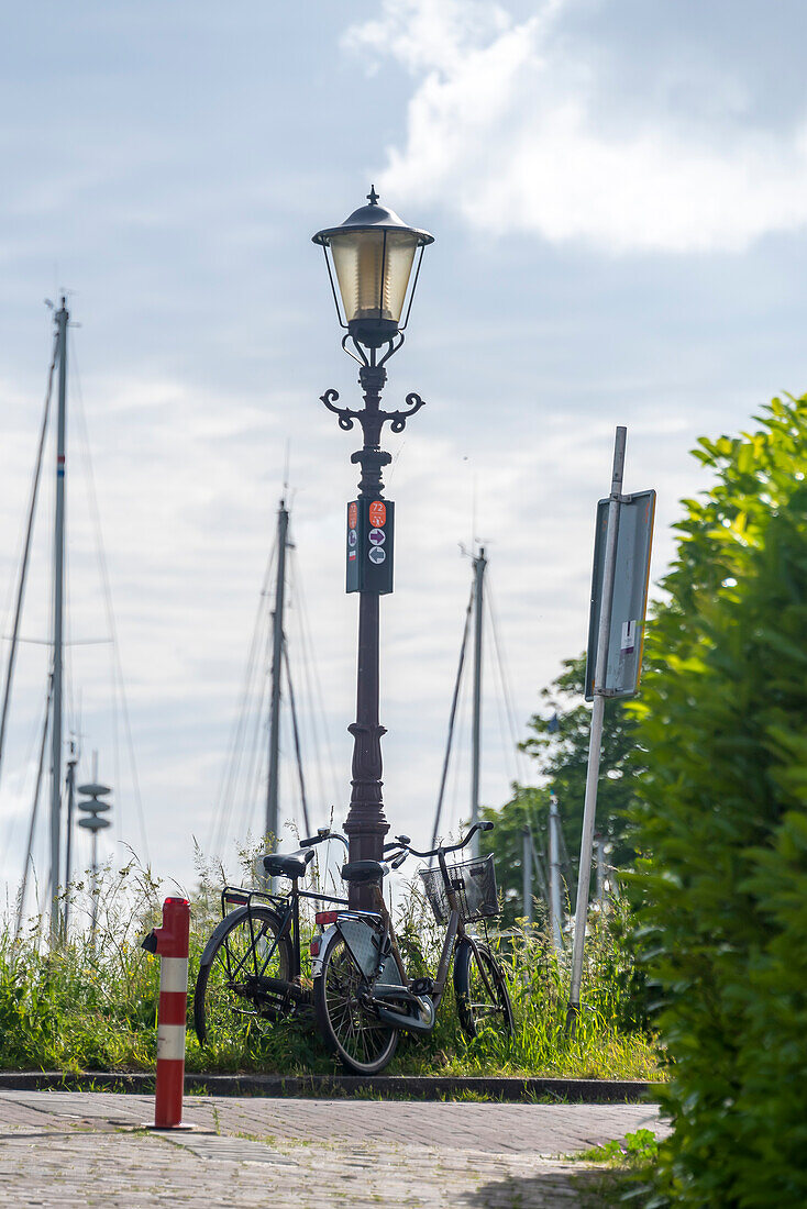 Fahrräder am Schellingwouderdijk, historische Straßenlaterne, Amsterdam, Noord-Holland, Niederlande