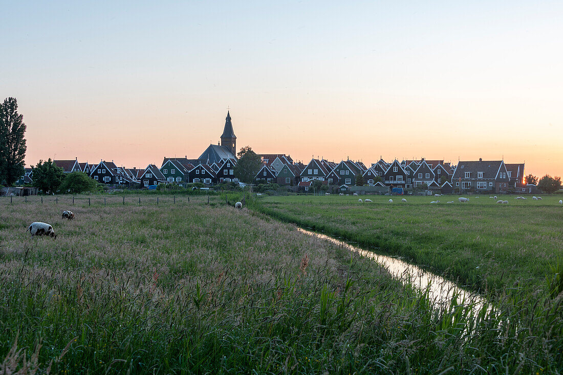 Sonnenuntergang, traditionelle Wohnhäuser, Dorfkirche, Wiese mit Schafen, Halbinsel Marken, Waterland, Noord-Holland, Niederlande
